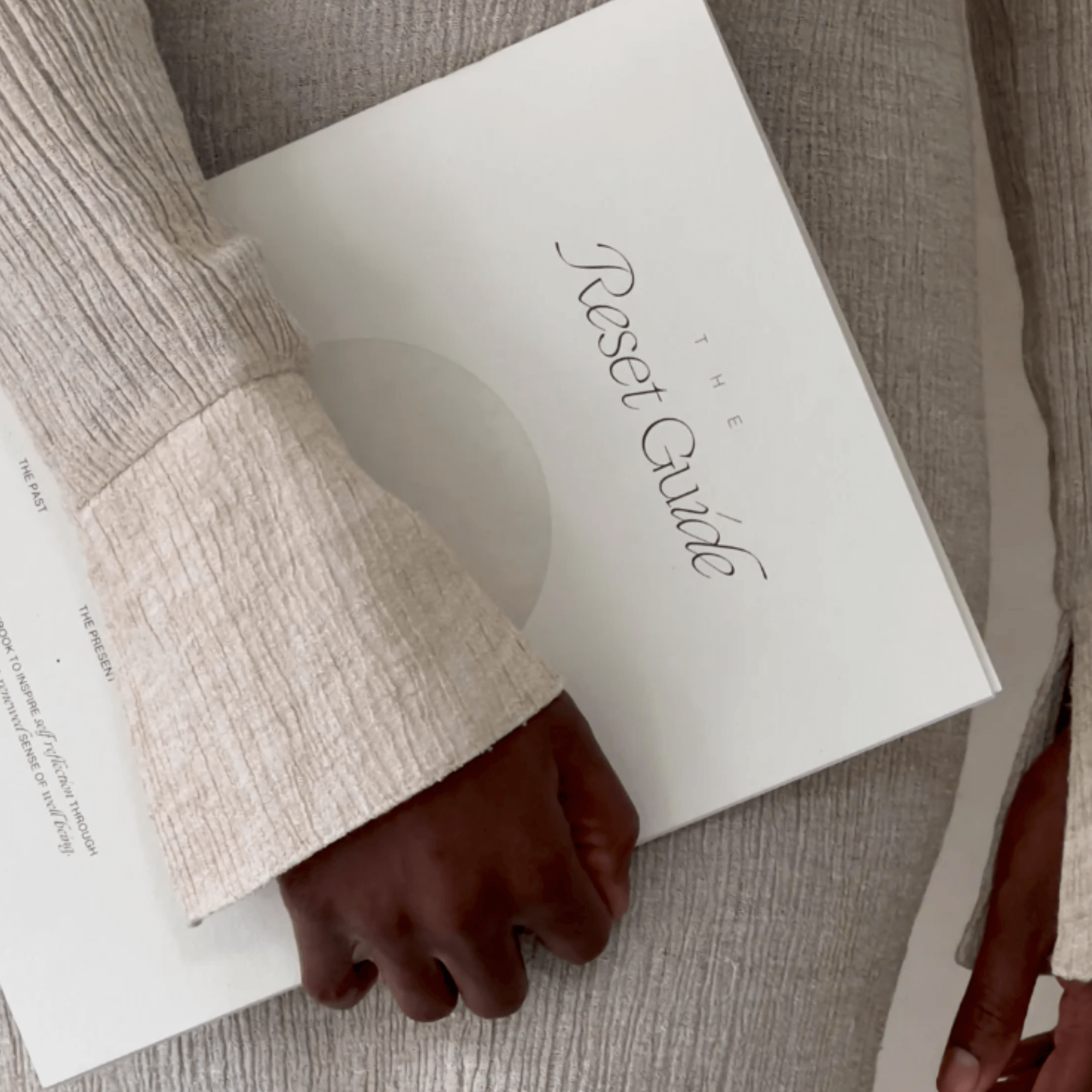 Person holding The Reset Guide workbook, a tool for self-discovery and authentic living.