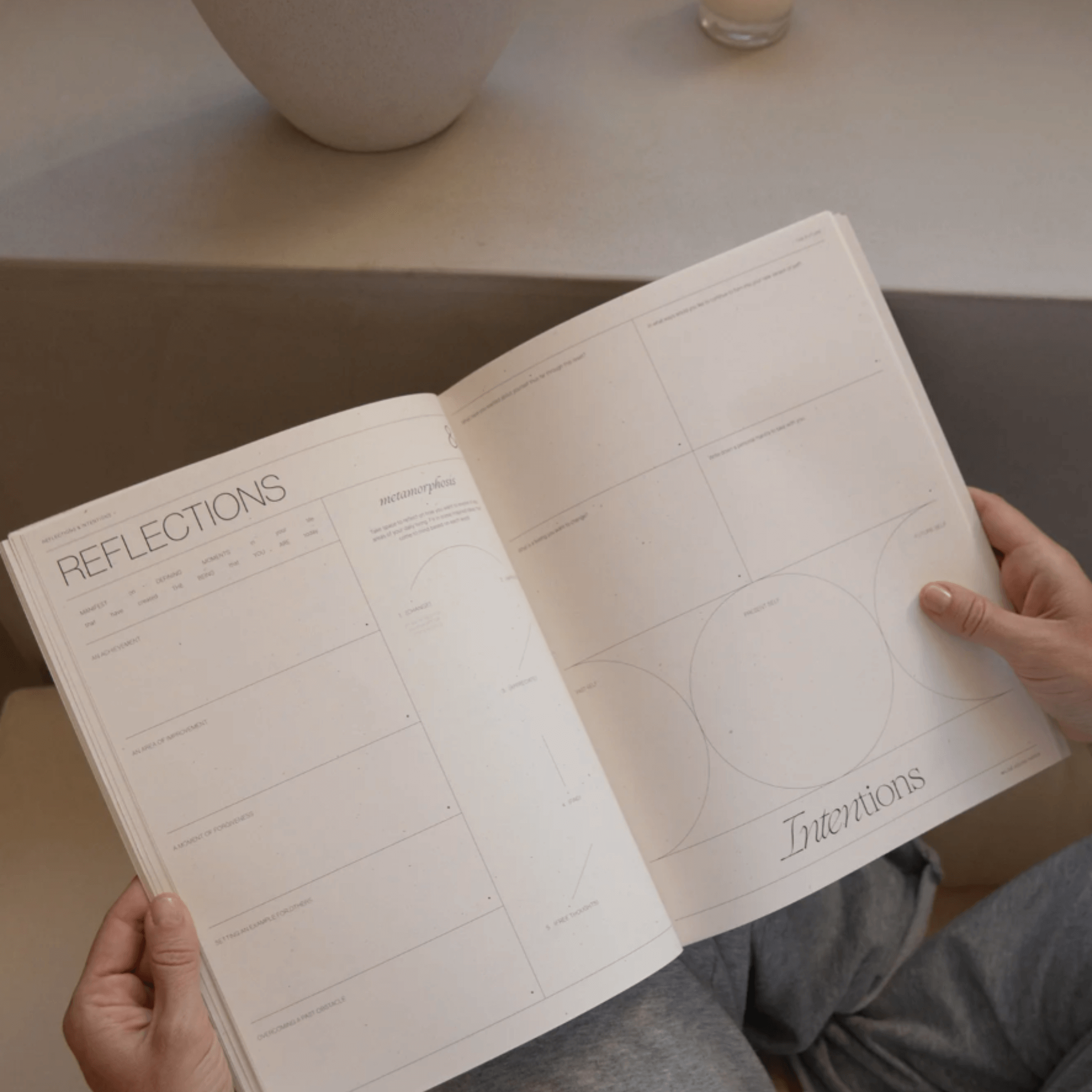 A person holding open a workbook page titled 'Reflections' with prompts for self-discovery and goal-setting.