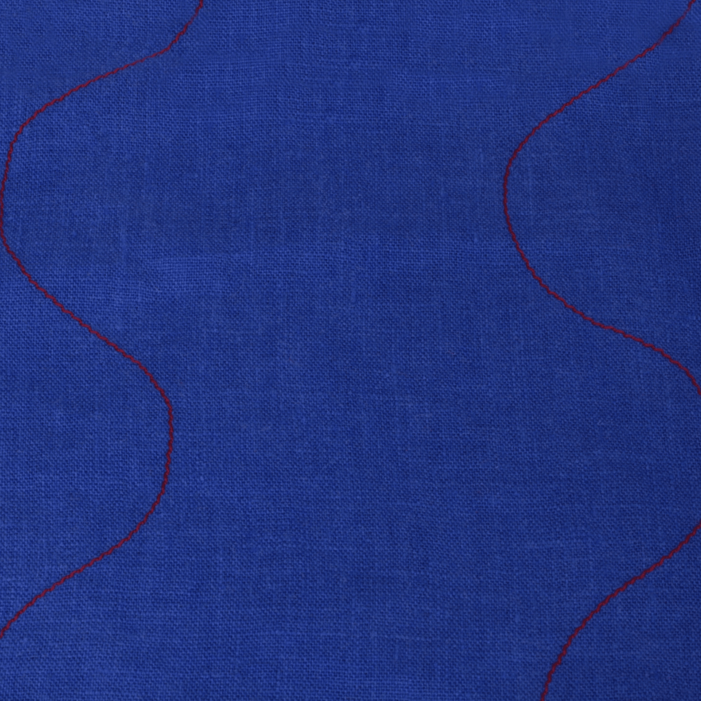 Wavy linen tea towel in vibrant blue with red stitching detail, perfect for kitchen use and decor.