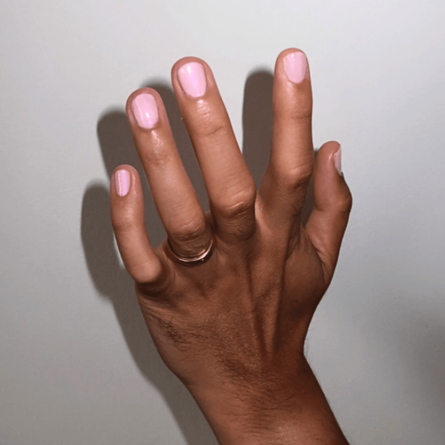 Hand showcasing Angel Nail Polish in sheer glowing baby pink with a delicate shine.