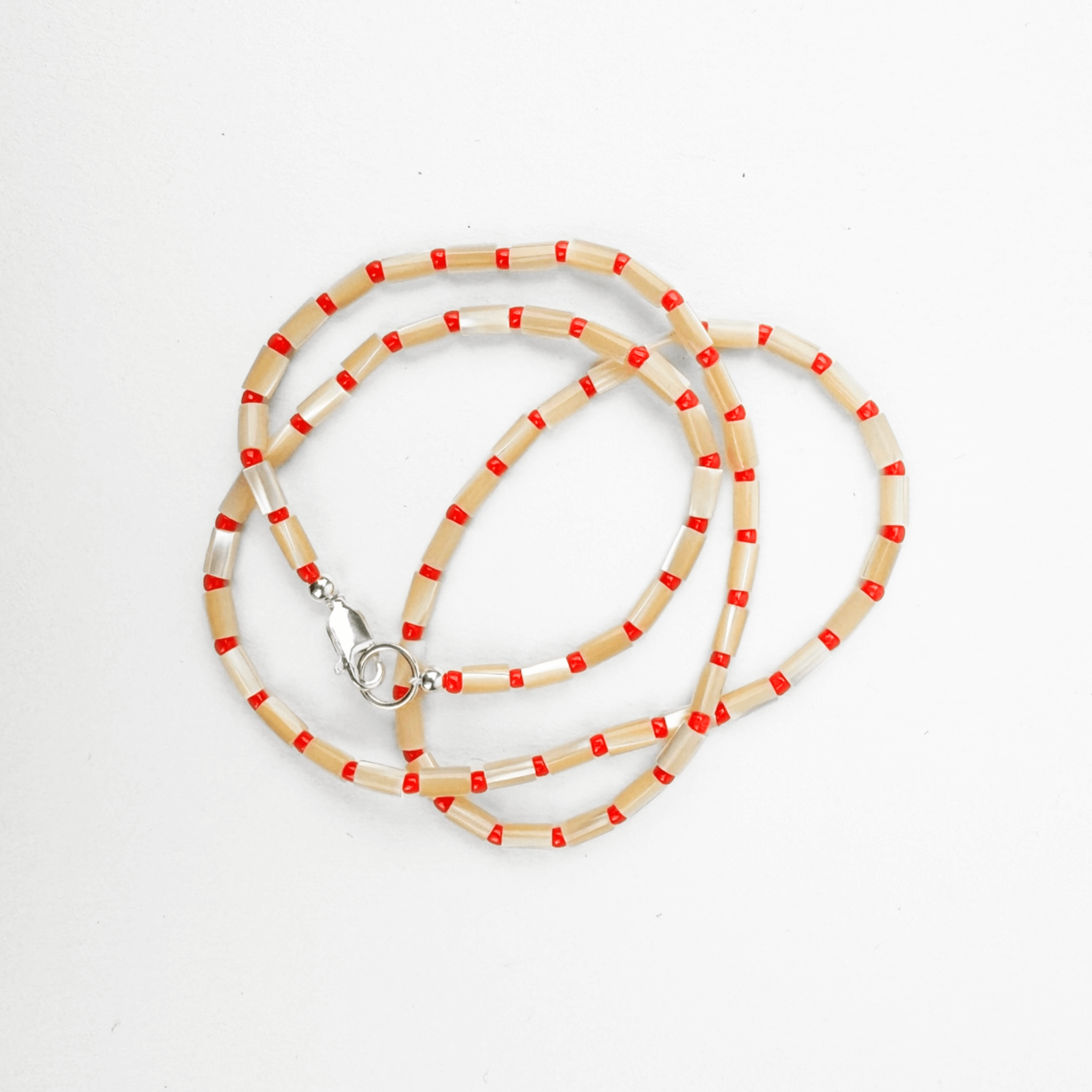 KARO NECKLACE featuring mother of pearl and Japanese glass beads in warm tones, strung on silk with gold accents.