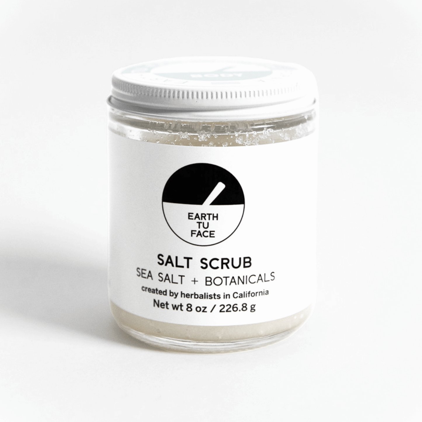 8 oz Salt Scrub jar with a clean design, combining sea salt and botanicals for exfoliation and hydration.