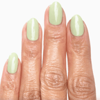 Close up of fingers with shiny sage green nail polish applying Forever Wear Chill Paint.