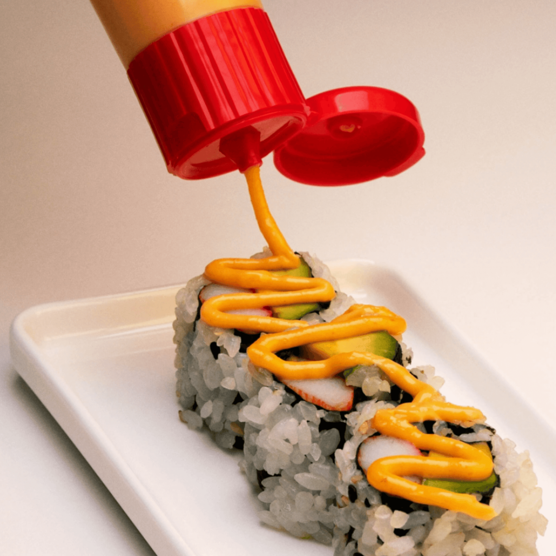 Pouring Japanese spicy mayo on sushi roll, showcasing creamy texture and vibrant flavor.