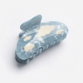 Lightweight Lucy Hair Claw with blue base and white clouds, adding magic to everyday hairstyles.
