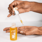 Person using dropper to apply PRECIOUS OILS ACTIVE INFUSION facial oil on their hand.