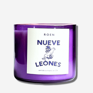 Nueve Leones candle in a striking purple jar, showcasing bold design and inviting ambiance.