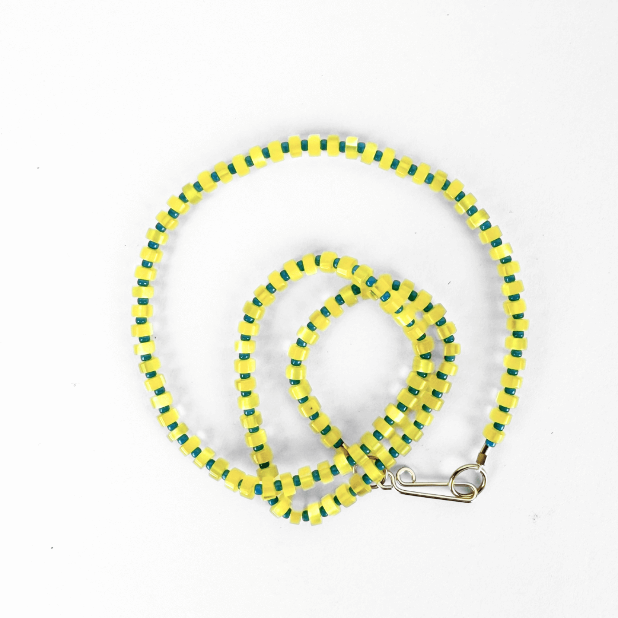 GALILEO NECKLACE features yellow and green optic glass beads on silk, finished with a sterling silver clasp.