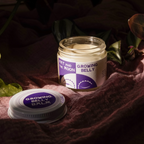 Growing Belly Balm jar by Fat and the Moon, nestled in soft fabric with plants, showcasing its creamy texture and soothing properties.