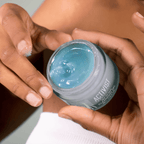 Person holding a jar of SEA TO SKIN Cleansing Gel, highlighting its vivid blue gel texture.