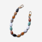 Handcrafted beaded bag charm in jade green, amber, and neutrals, perfect for adding style to any bag.