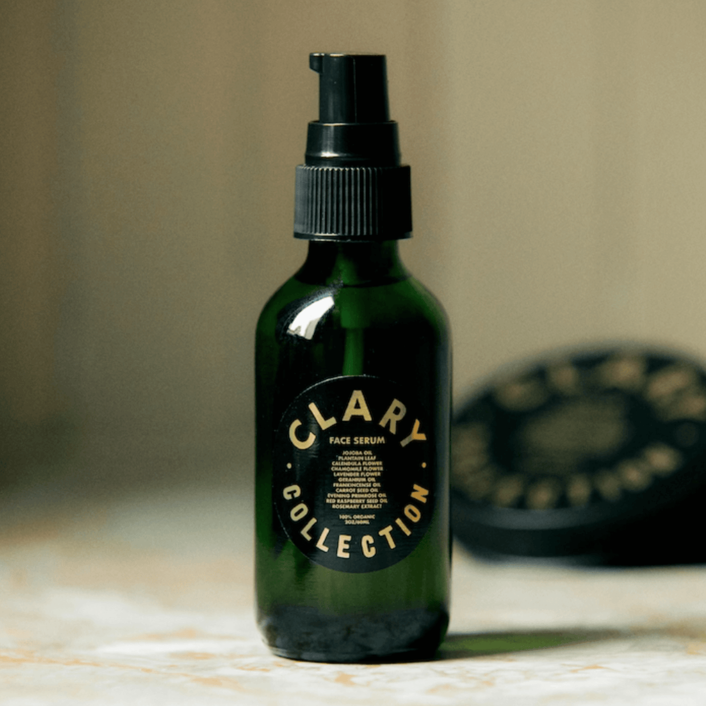 Clary Collection's Face Serum in a green glass bottle, designed for hydration and skin rejuvenation.