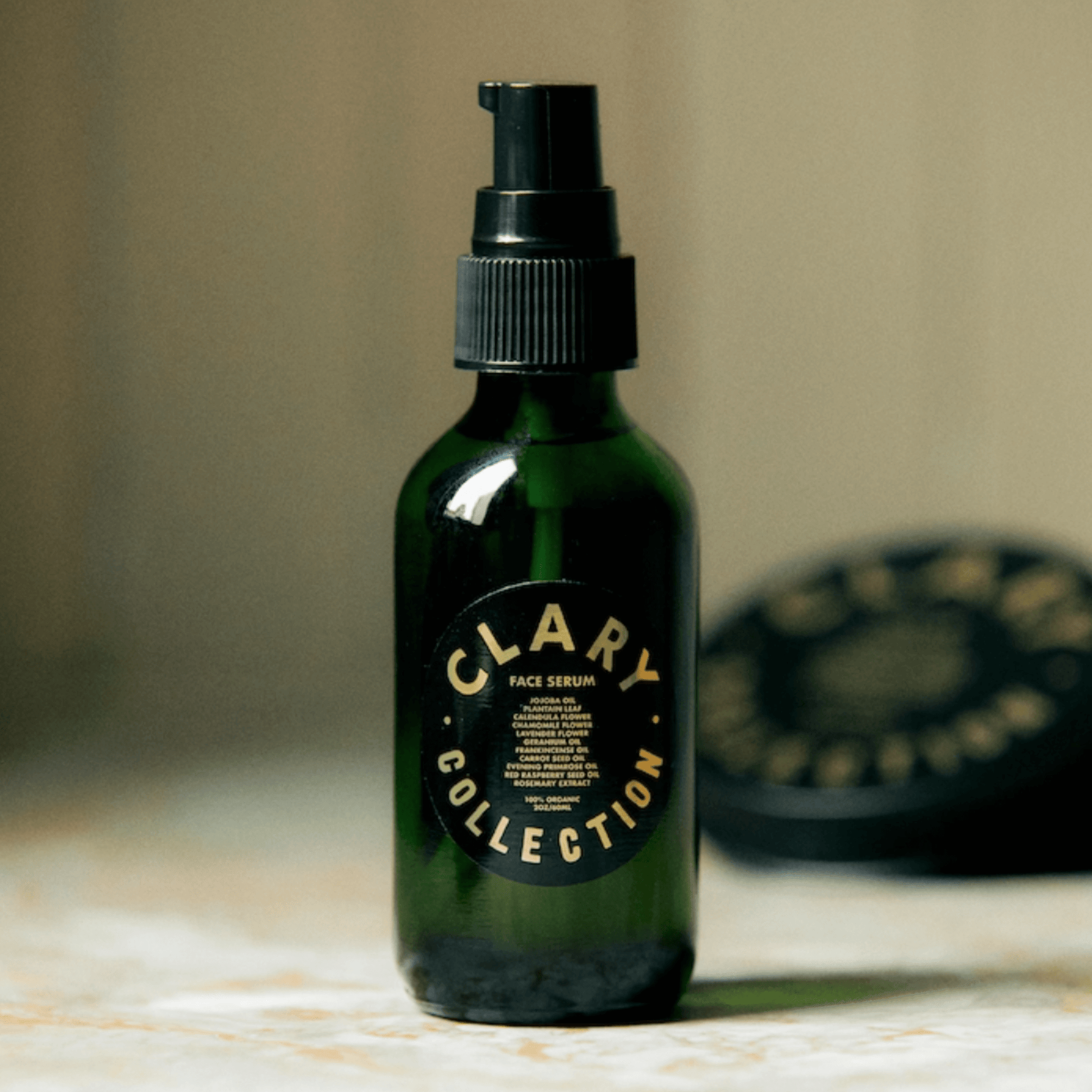 Clary Collection's Face Serum in a green glass bottle, designed for hydration and skin rejuvenation.
