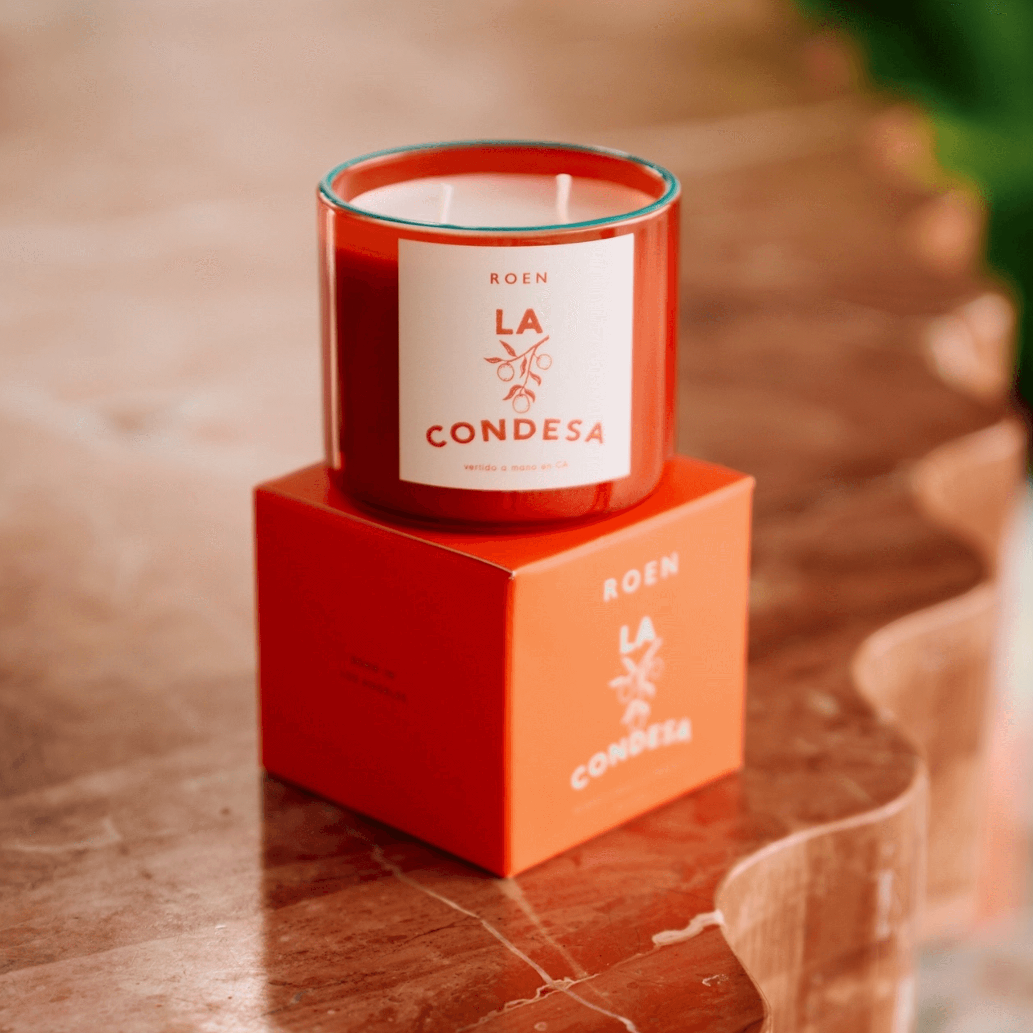 LA CONDESA candle on a marble table, featuring vibrant packaging and a tropical, chic design.