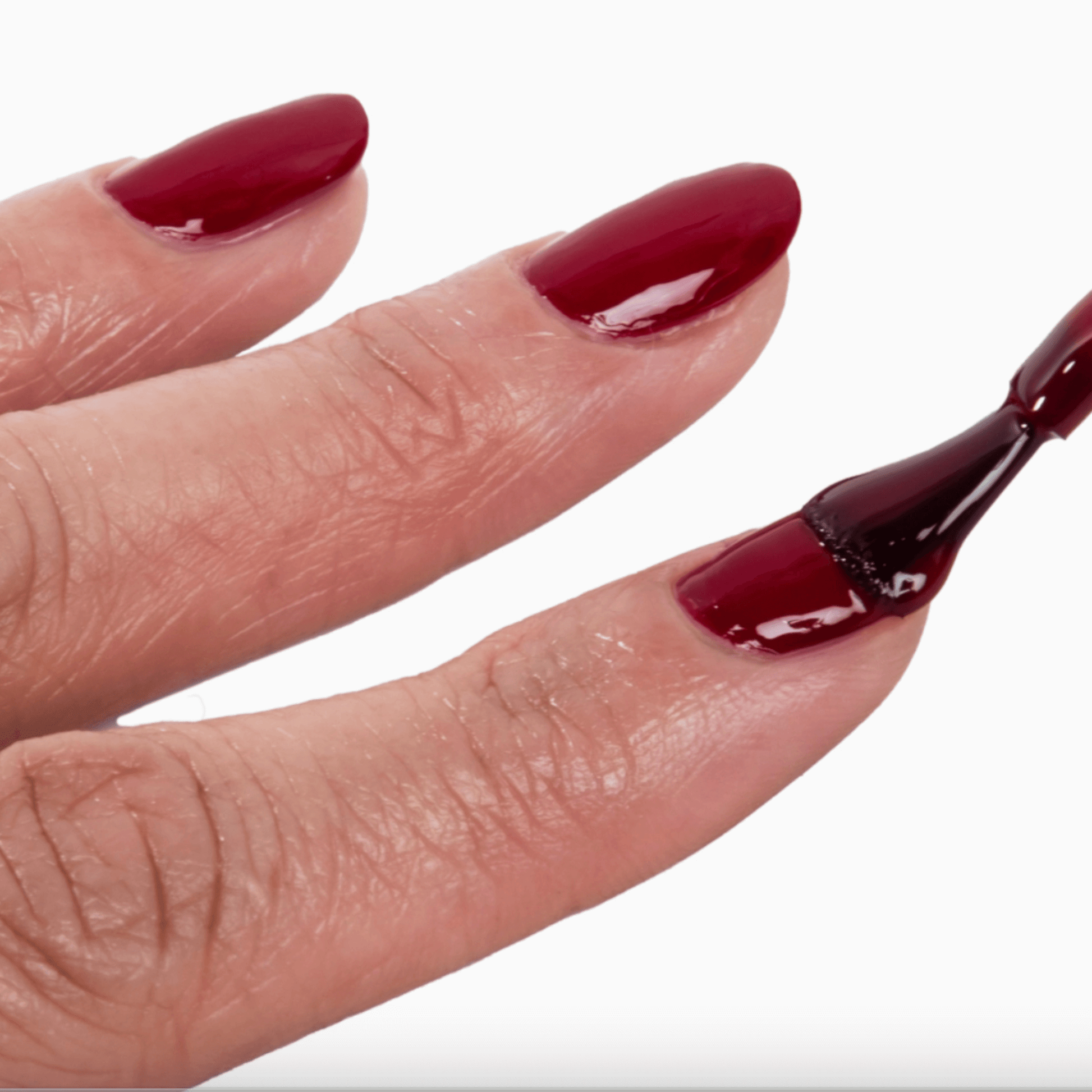 Close-up of nails with FOREVER WEAR CHILL PAINT in Natty Wine, showcasing deep red polish application.