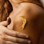 Close-up of olive balm applied to shoulder skin, showcasing its soothing and moisturizing properties.
