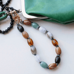 Handcrafted beaded bag charm in jade green, amber, and soft neutrals, perfect for adding style to any bag.