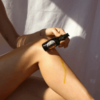 Woman applying RENEW + REPAIR OIL body oil to her leg for skin hydration and healing.