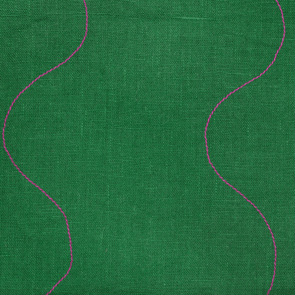 Close-up of a vibrant green linen fabric with pink wavy stitched details, perfect for kitchen or bath use.