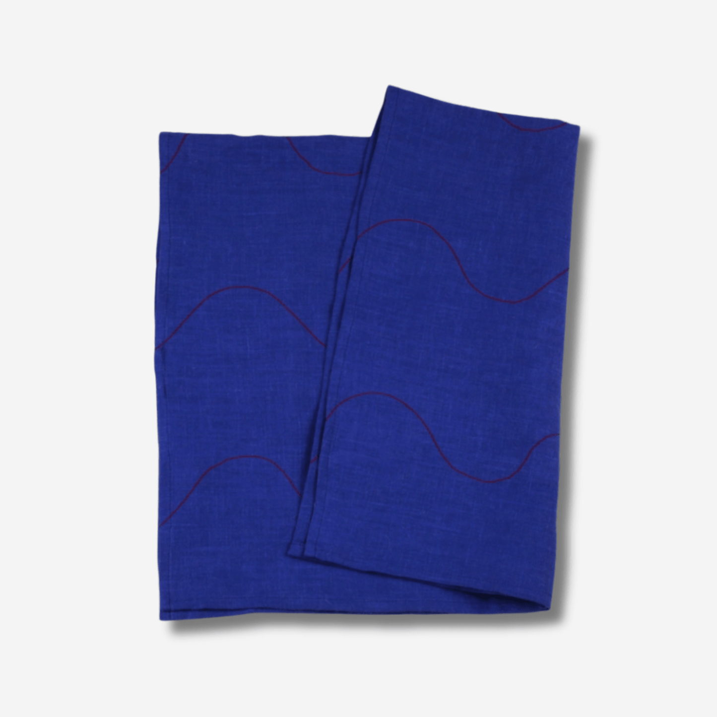 Wavy linen tea towel in vibrant blue with red accents, featuring stitched details and a hanging loop.