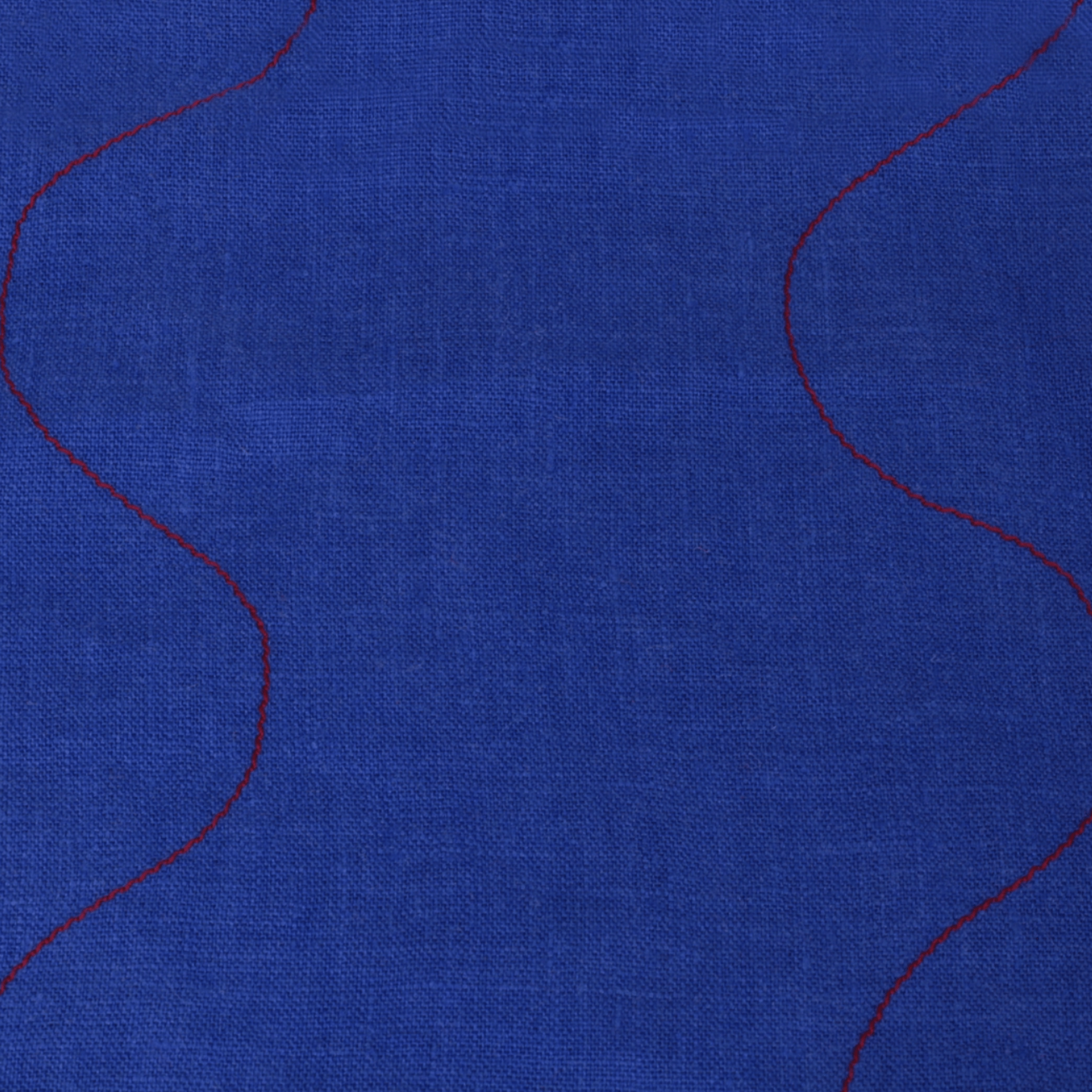 Wavy linen tea towel in vibrant blue with red stitching detail, perfect for kitchen use and decor.