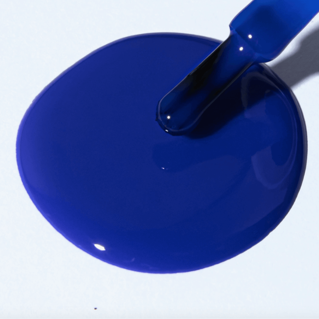 A vibrant electric blue polish spill showcasing Forever Wear Chill Paint - Cobalt Klein for stunning manicures.