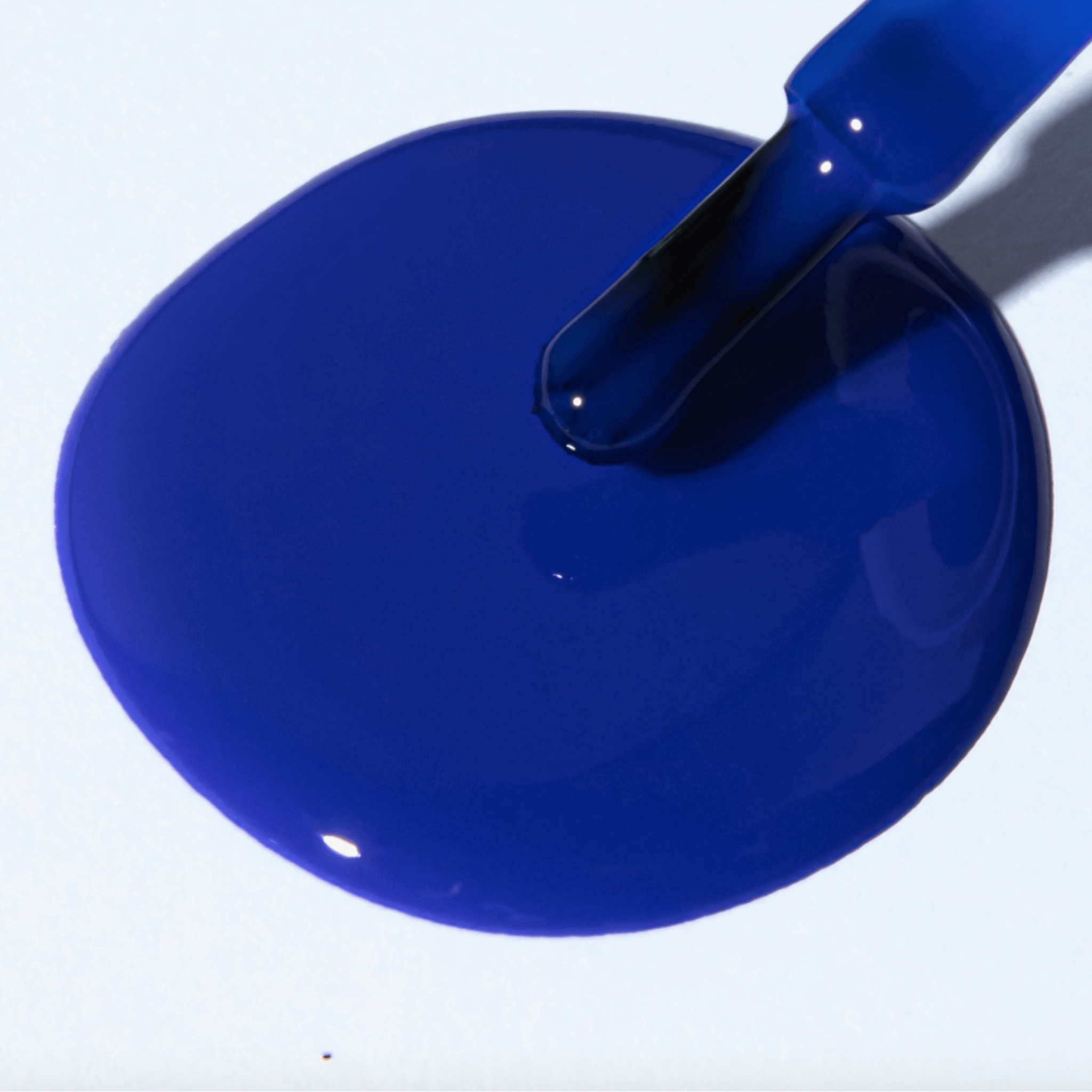 A vibrant electric blue polish spill showcasing Forever Wear Chill Paint - Cobalt Klein for stunning manicures.
