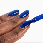 Hand with cobalt blue nails applying Forever Wear Chill Paint for a vibrant, long-lasting manicure.