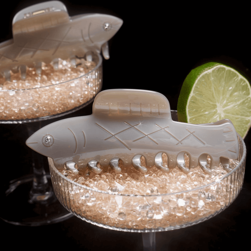 HERRING HAIR CLAW in a whimsical fish design displayed with citrus slices in elegant glass bowls.
