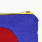 Close-up of the CIRCLE LINEN ZIPPER POUCH showing vibrant colors and bold yellow brass zipper detail.
