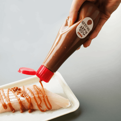 Drizzling MISO GLAZE over fresh fish fillet for a flavorful marinade or BBQ upgrade.