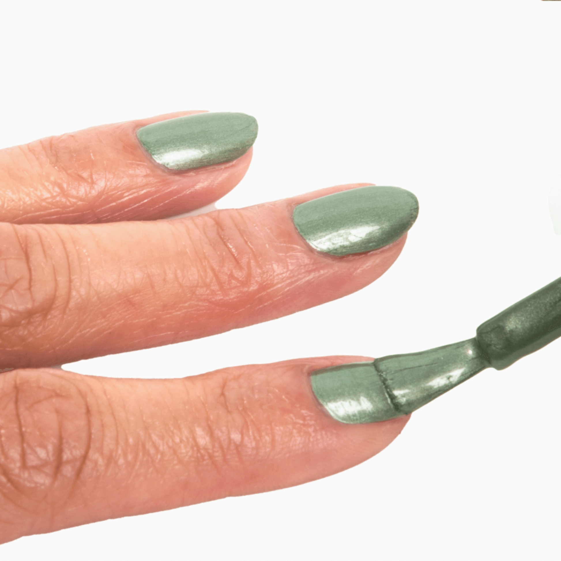 Close-up of a hand applying silvery sage nail polish with shimmer, showcasing Forever Wear Chill Paint.