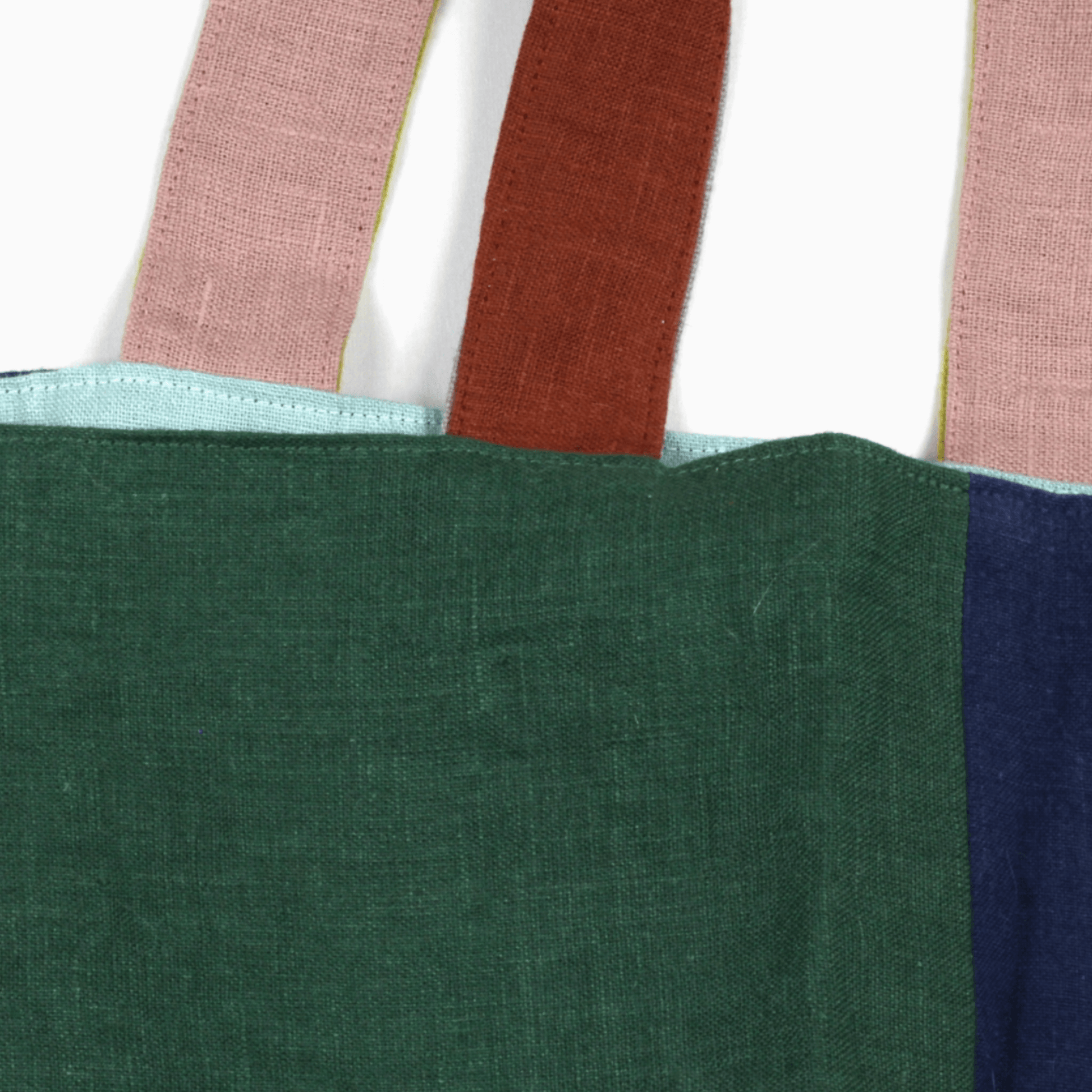 Close-up of the Small Linen Tote Bag - Wanderer featuring colorful handles and two-tone linen fabric.
