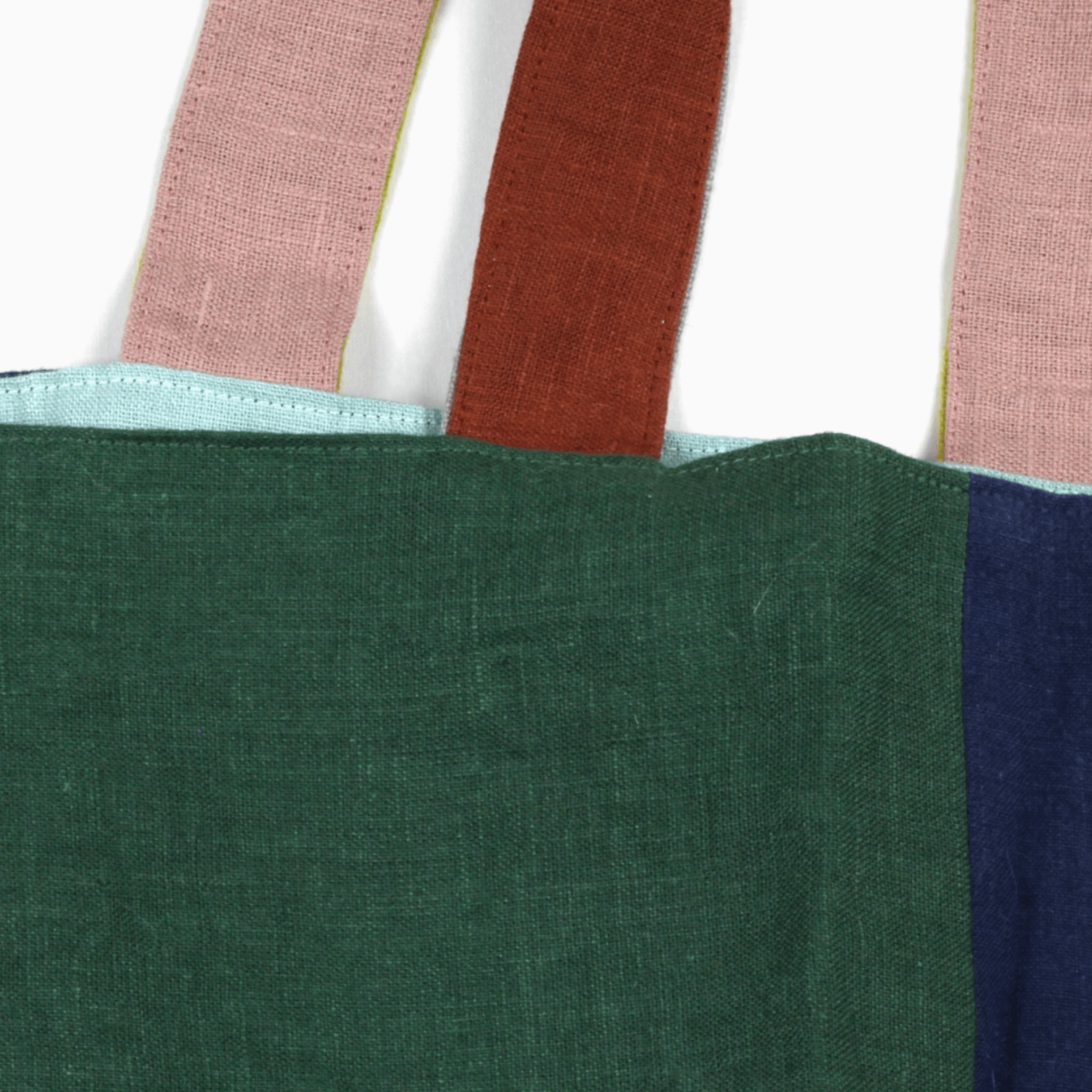 Close-up of the Small Linen Tote Bag - Wanderer featuring colorful handles and two-tone linen fabric.