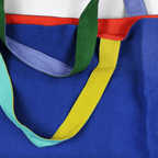 Colorful oversized linen tote bag featuring red, blue, and green straps, perfect for beach days and everyday use.