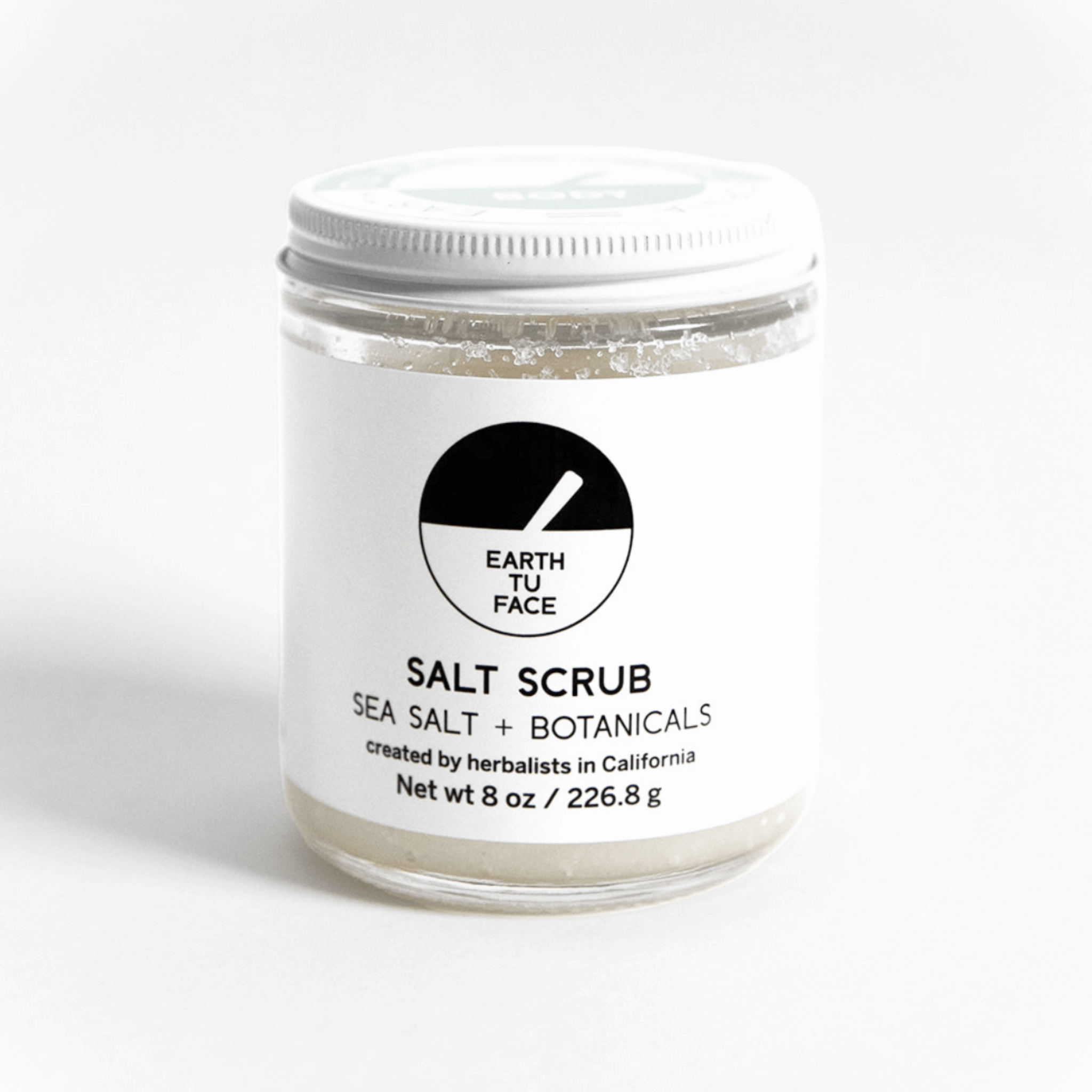 8 oz Salt Scrub jar with a clean design, combining sea salt and botanicals for exfoliation and hydration.