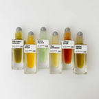 A lineup of natural perfume roll-ons including Fortuna's Darling and others with vibrant, colorful liquids.