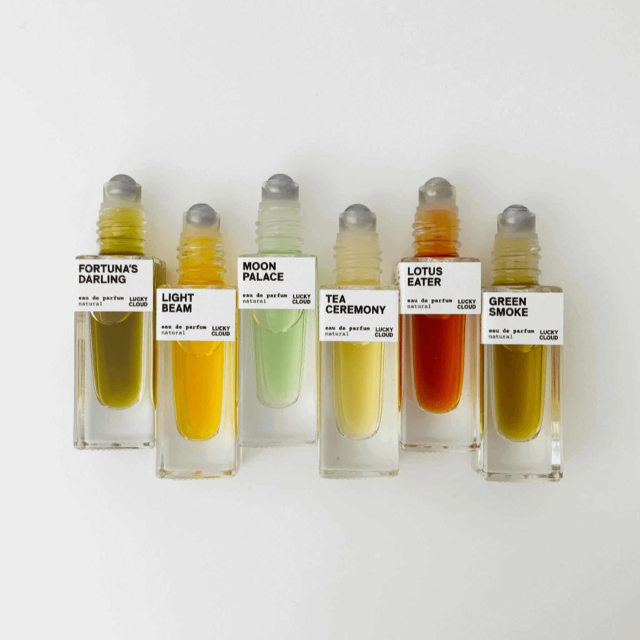 Array of six natural perfumes including Green Smoke, featuring vibrant colors and eco-friendly packaging.