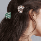 Two mini agate hair claw clips in green and brown styles holding back long dark hair for a chic hairstyle.