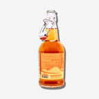 Kumquat fruit-infused vinegar in a glass bottle with a swing top, showcasing vibrant color and label details.